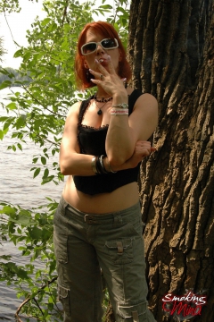 Busty babe smoking and posing sexy in the woods