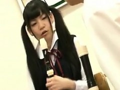 Cute Asian teen in pigtails practices the flute with her te