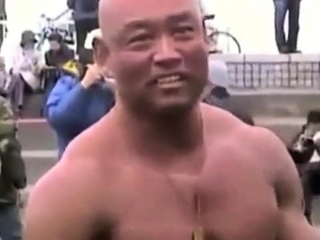 Asian bodybuilder barely covered at the beach