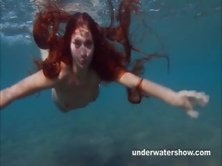 Julia is swimming underwater nude in the sea